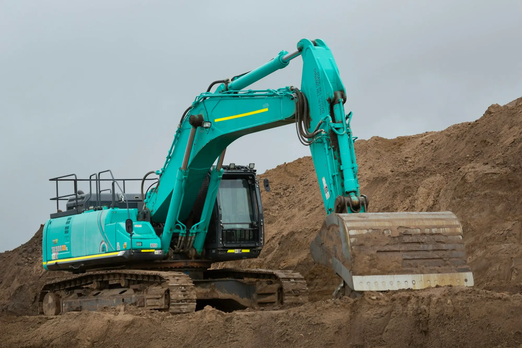 Excavator digging into a pile of earth on a civil works site in Victoria