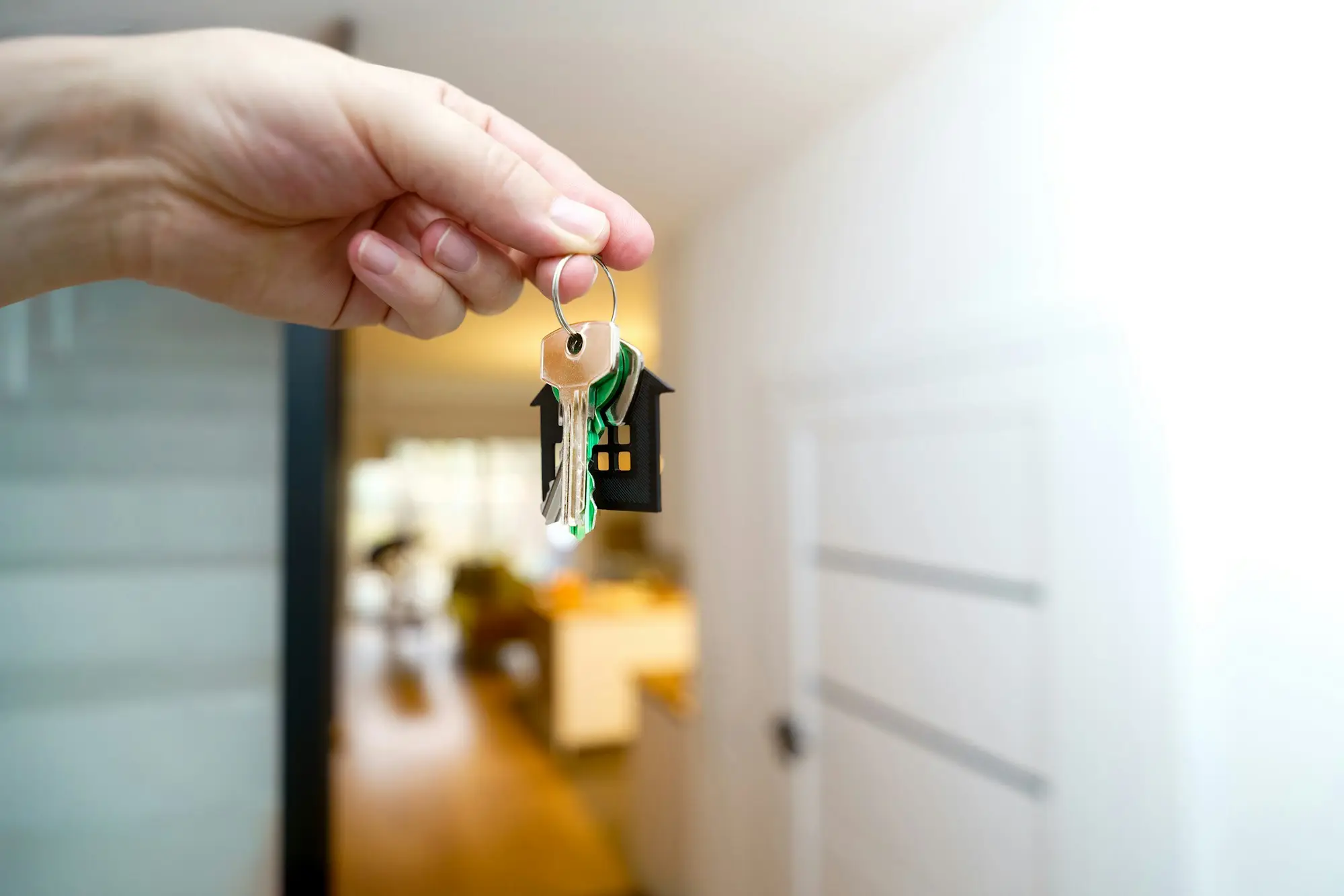 Keys held up in front of a property entrance at settlement