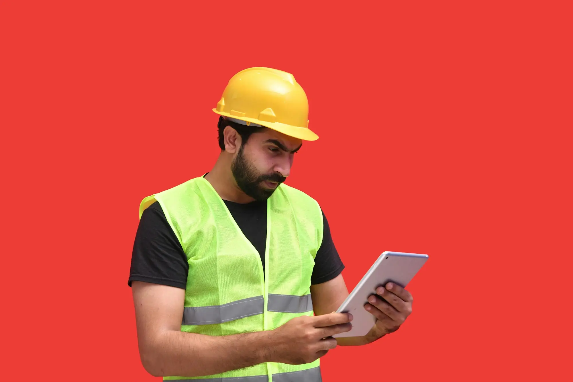 Tradesperson in a hard hat using a tablet on site