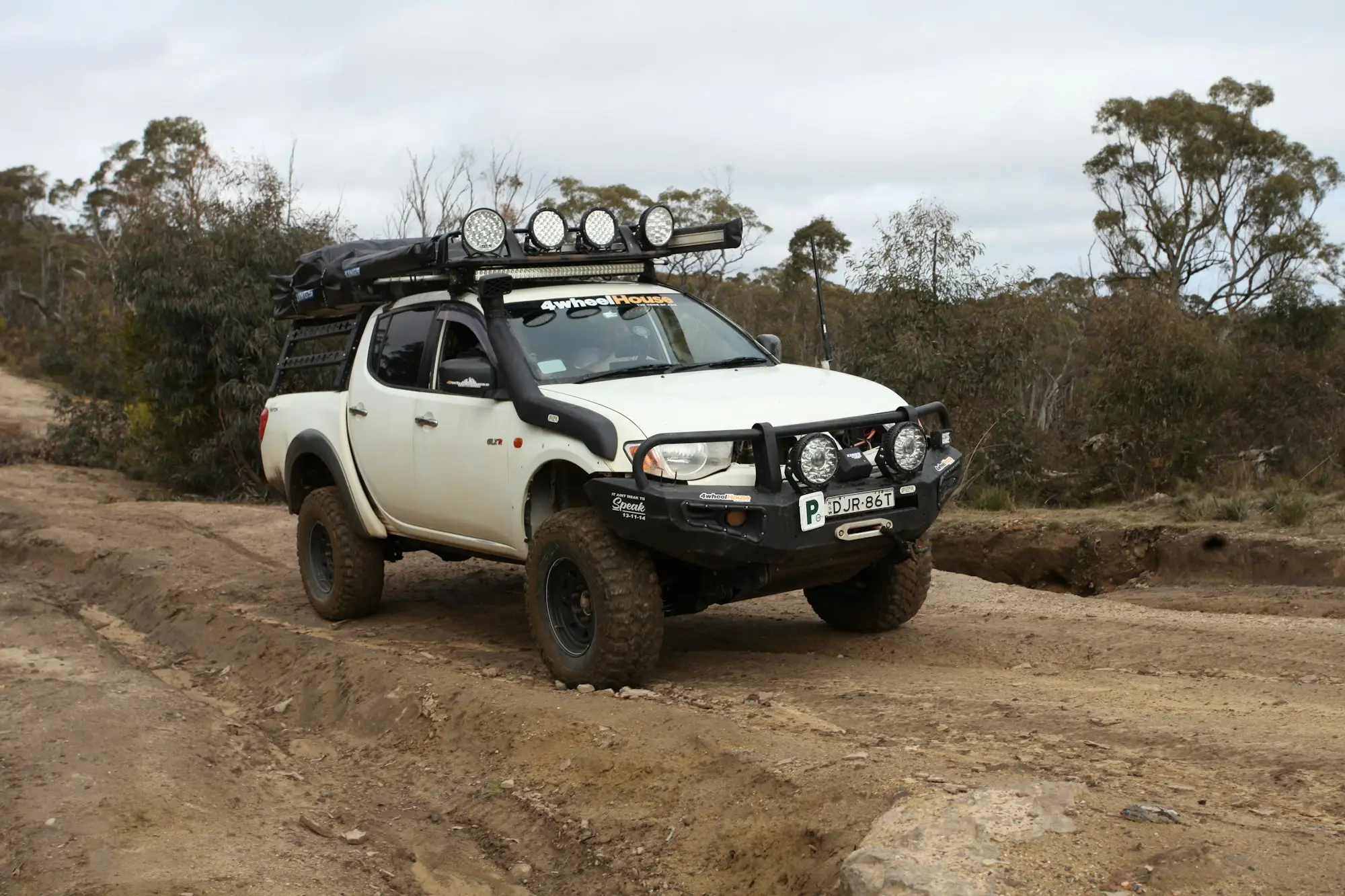 White work ute driving along a dirt track